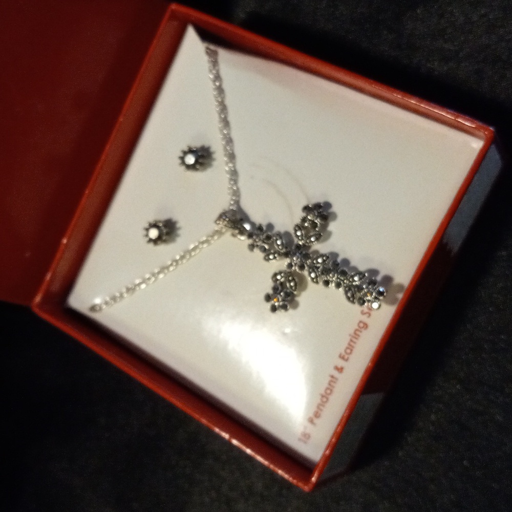 Silver plated crystal encrusted cross pendant on 18 inch chain.